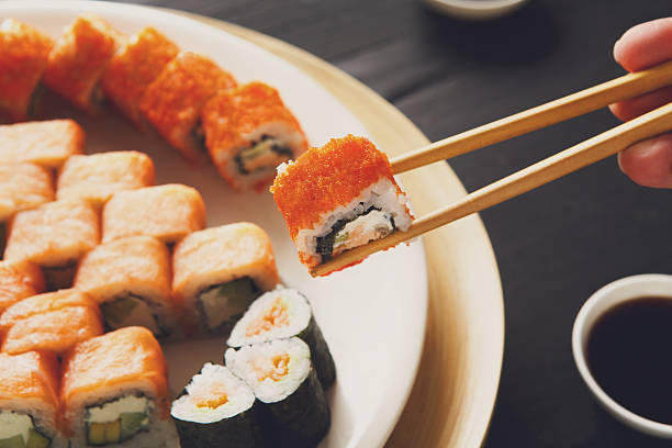 istock Eating sushi rolls at japanese food restaurant 522398514