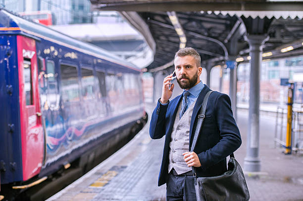 istock Businessman with smartphone, making a phone call, train platform 522398642