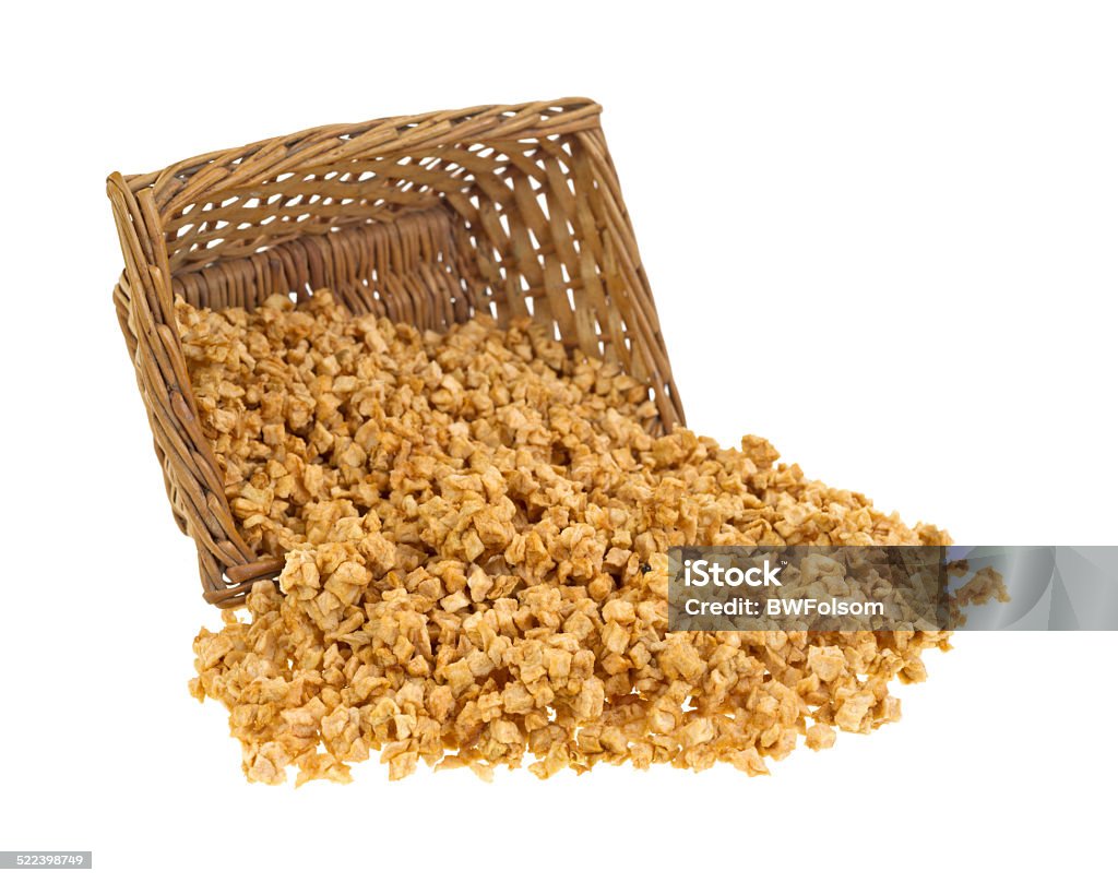 Dehydrated apple pieces spilling from basket A small wicker basket with apple pieces that have been dehydrated spilling onto a white background. Block Shape Stock Photo