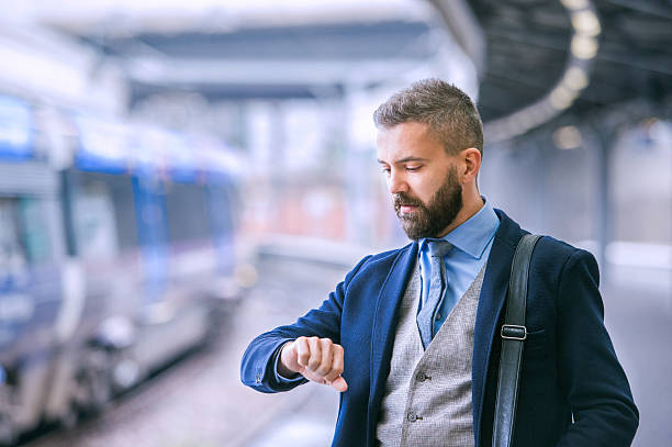 Close up, hipster businessman waiting at the train station Close up of hipster businessman waiting at the train station platform, looking at watch on hand london england rush hour underground train stock pictures, royalty-free photos & images