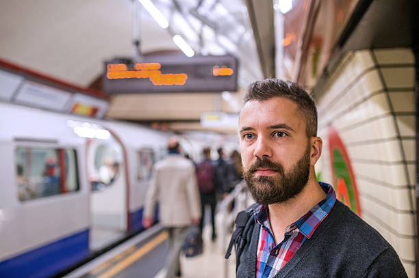 istock Young hipster man standing at the underground platform waiting 522399686