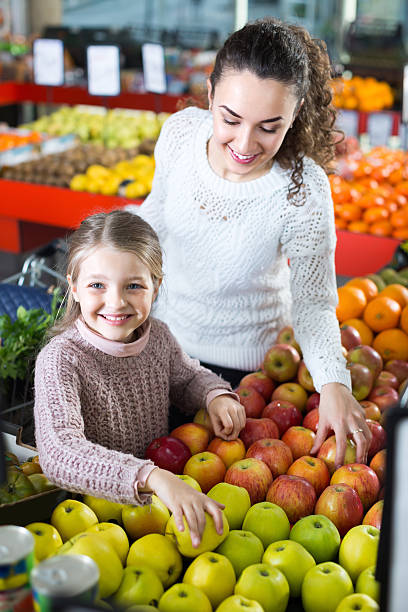 madre e figlia di acquistare mele - jona gold foto e immagini stock