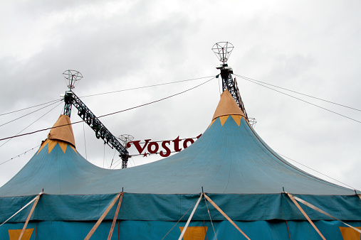 Circus Big Top and entrance lighting, A505 near Royston, Cambridge, England. Traditional colorful tents and bright lights typify the old characteristics of circus life, which no longer features wild animals but still provide hours of fun for families and children