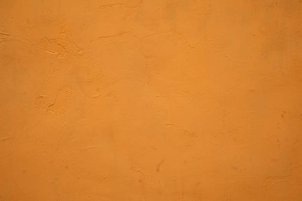 istock Texture of old wall covered with yellow stucco 522403785