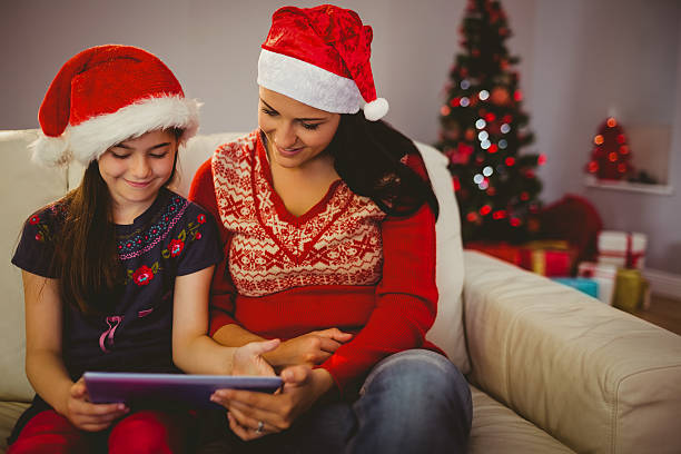 istock Festive mother and daughter using tablet 522403915
