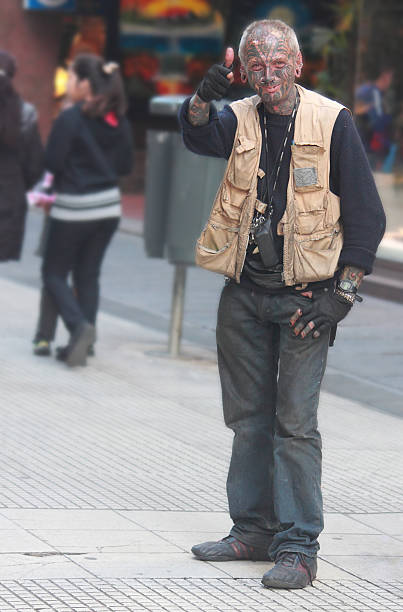 tattooed man is showing thumb Buenos Aires, Argentina - April 27, 2014 - tattooed man is showing thumb on a pedestrian streen in Buenos Aires pollex stock pictures, royalty-free photos & images