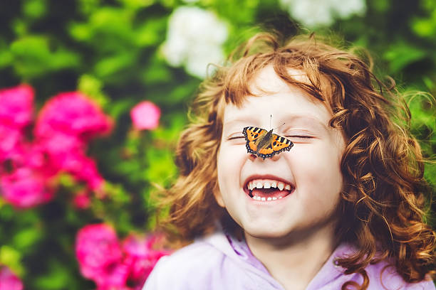 rire fille avec un papillon sur le nez - ailes du nez photos et images de collection