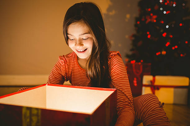 istock Little girl opening a glowing christmas gift 522419673