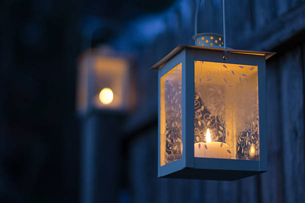 istock Lit candle in a lantern on a fence at twilight 522419815