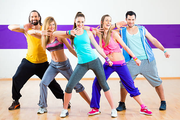 Group of men and women dancing zumba fitness choreography in dance school