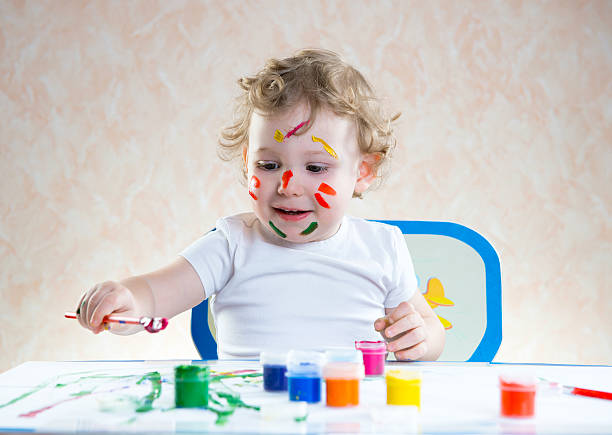 istock Cute little child painting 522421117