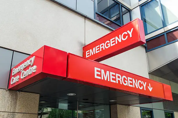Entrance to hospital emergency department at St Vincent's Hospital in Melbourne, Australia.  The sign is red with the word EMERGENCY prominently displayed. It can be used to illustrate various healthcare, medical and emergency concepts, from afflictions such as stroke or heart attack, diseases such as HIV or cancer, and accidents such as road trauma or sporting injury.