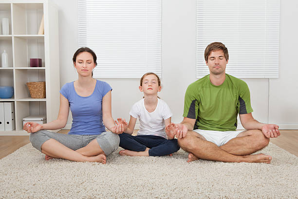 istock Family Practicing Yoga At Home 522424151