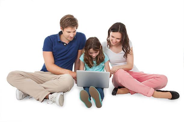 istock Family Sitting With Laptop Over White Background 522424155