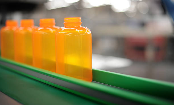 Orange bottles green conveyor stock photo