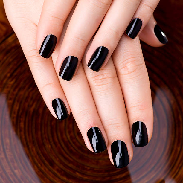 istock Beautiful women hands with black manicure 522441073