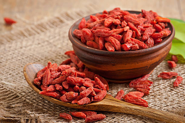 Red dried goji berries in wooden spoon stock photo