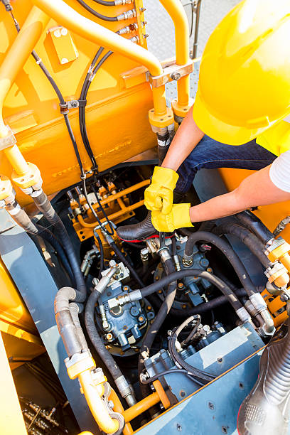 Asian mechanic repairing construction vehicle