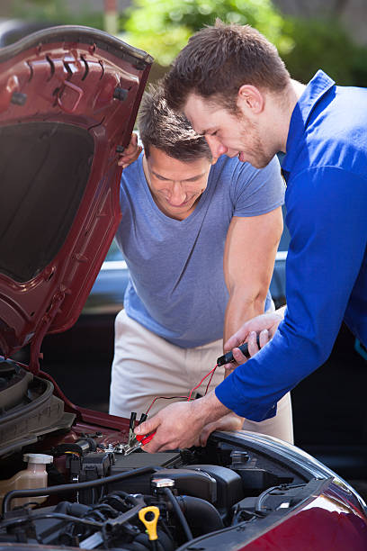 istock Car Owner With Mechanic Testing Car Battery 522451201