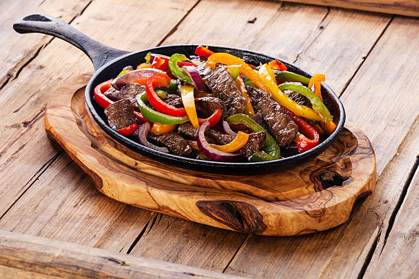 Beef Fajitas in pan Beef Fajitas with colorful bell peppers in cast iron pan fajita photos stock pictures, royalty-free photos & images