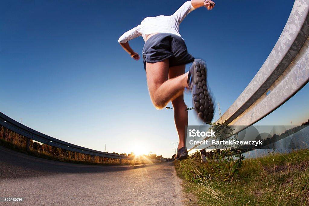 Man running on road during sunset Man running fast on road during sunset. Jumping Stock Photo