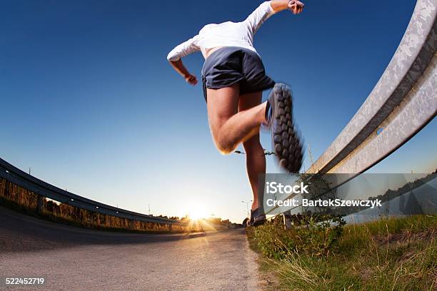 Man Running On Road During Sunset Stock Photo - Download Image Now - Jumping, Active Lifestyle, Activity