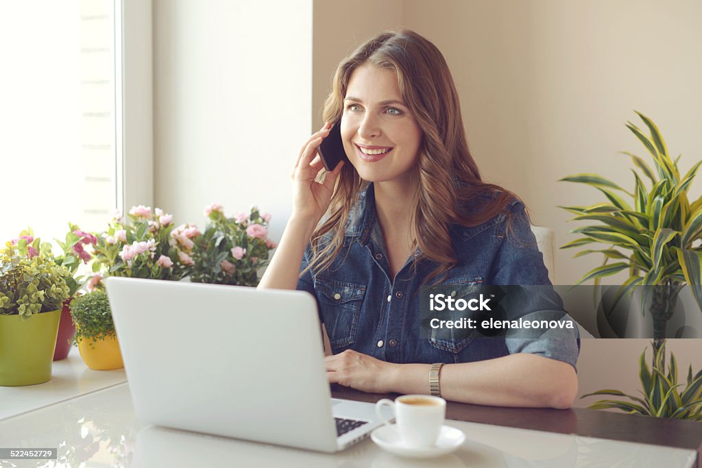 woman working at a laptop Young woman working at a laptop at home. 30-34 Years Stock Photo