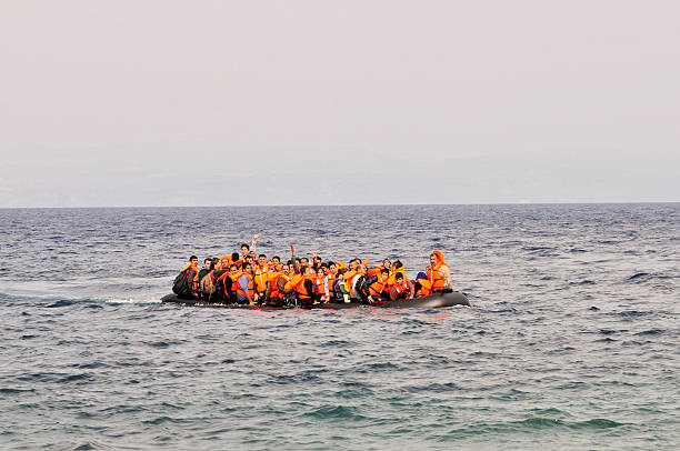 Refugees arrive at Greek island Lesvos Lesvos, Greece- October 20, 2015: Refugees arriving in Greece in dingy boat from Turkey with Syrian, Afghanistan and African refugees .Their over crowded boat is still at sea an will land at the North coast of Lesvos near Molyvos, Eftalou and Skala Sikaminia. immigrant stock pictures, royalty-free photos & images