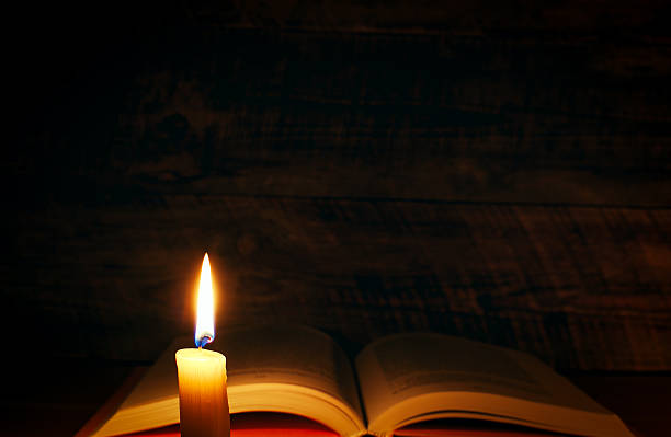 istock concept of knowledge, vintage book with candle 522456496