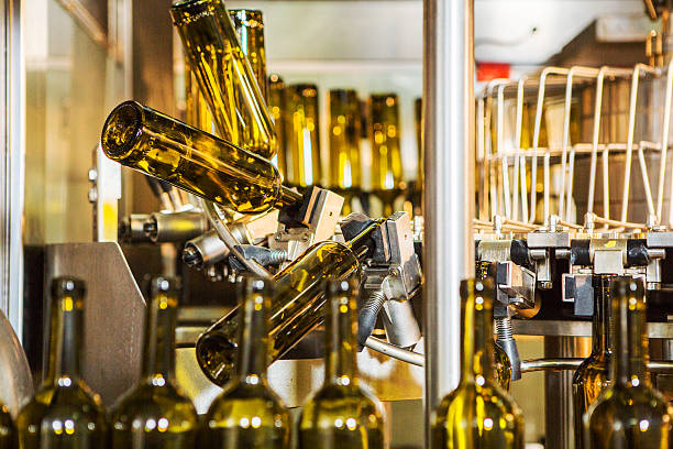 senza etichetta vetro bottiglie in macchina imbottigliamento sul moderna azienda vinicola - bottling plant winemaking wine factory foto e immagini stock