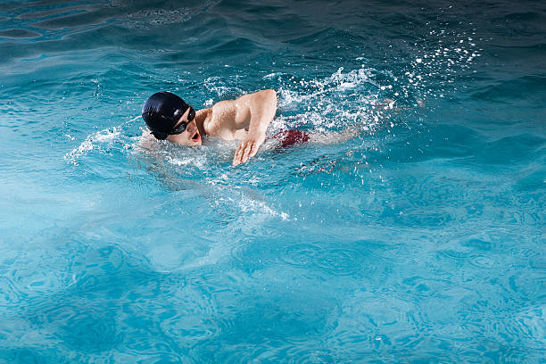 istock Young man swimming the front crawl in a pool 522458770