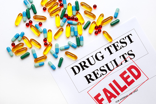 concept drug test results are failed on white background with pills