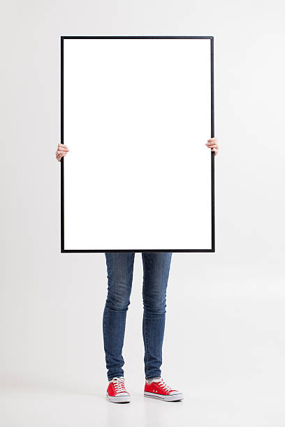 istock woman with blank poster on wall background 522462028