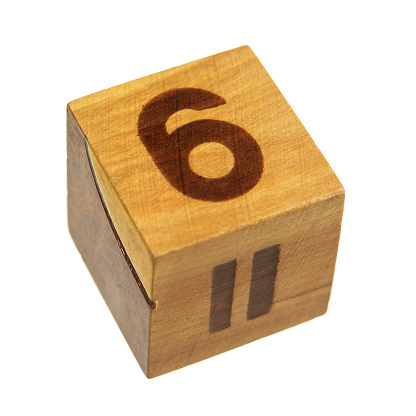 Isolated on white wooden block with number six. Shallow depth of field