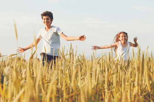 Children running in wheat field