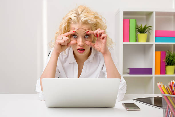 donna lavorando su computer e con gli occhi aperti - freaking foto e immagini stock