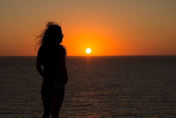 istock Pretty lady regarding the outstanding sunset scenery 522464688