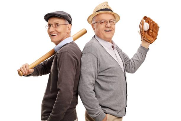 Two old friends and baseball teammates Studio shot of two old friends and baseball teammates posing together isolated on white background old baseball stock pictures, royalty-free photos & images