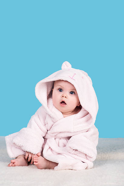 istock cute baby sitting on blanket in pink bathrobe 522468586