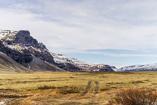istock Montain range and plains with field road in view 522468702