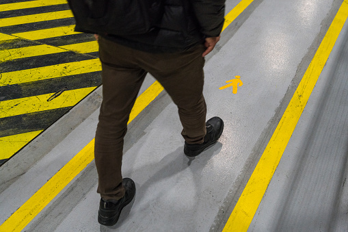 Worker walking on the protection pathway with yellow lines on the floor in the factory