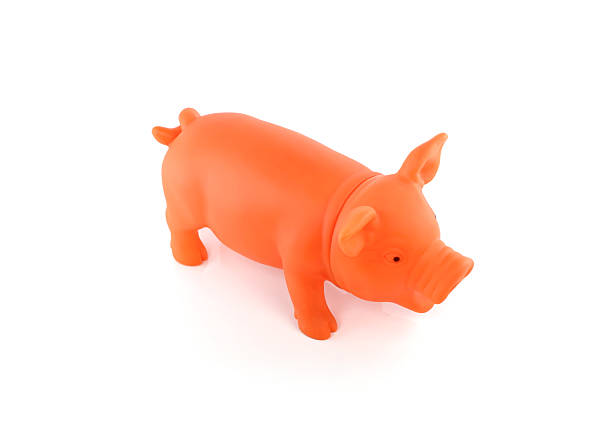 Small french pink marzipan cake formed as a pig isolated on black background