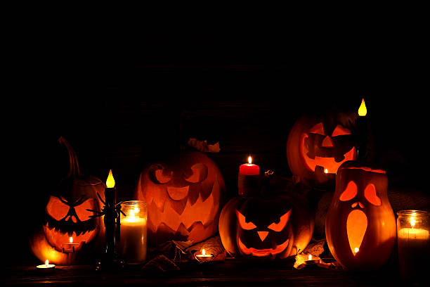 istock Halloween pumpkins with candle on brown wooden table 522471418