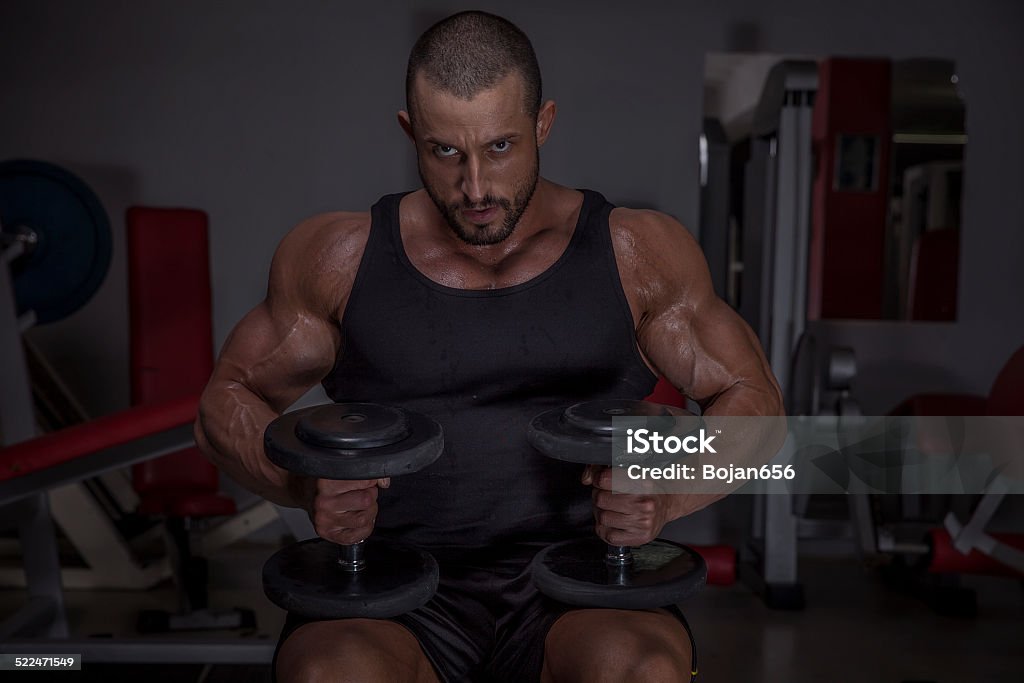 Bodybuilder In tThe Gym Handsome Body Builder Exercise With Dumbbells. Active Lifestyle Stock Photo