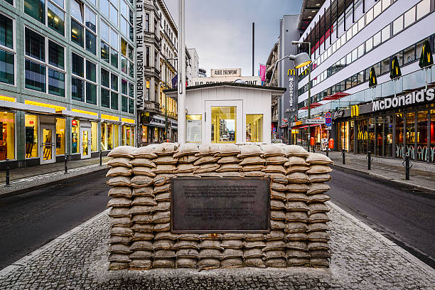 Checkpoint Charlie in Berlin Berlin, Germany - September 20, 2013: The Checkpoint Charlie monument. The crossing point between East and West Berlin became a symbol of the Cold War. soldier on the wall stock pictures, royalty-free photos & images