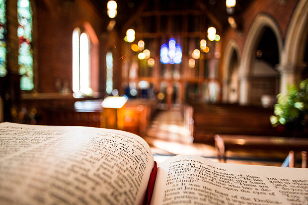 Open Bible on Altar inside Anglican Church Bible open at the book of John inside an Anglican Church of England church. The focus is on the foreground of the bible, while in the background, defocused, are the pews and arches of the historic eighteenth century building. Horizontal colour image with copy space.  preacher photos stock pictures, royalty-free photos & images
