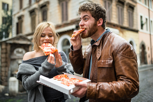 couple eating a pizza in italy