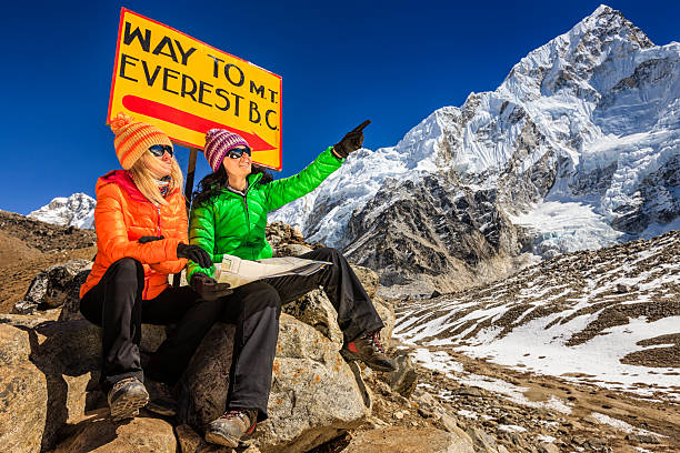 istock Young women studying map next to signpost, Nepali Himalaya 522475600