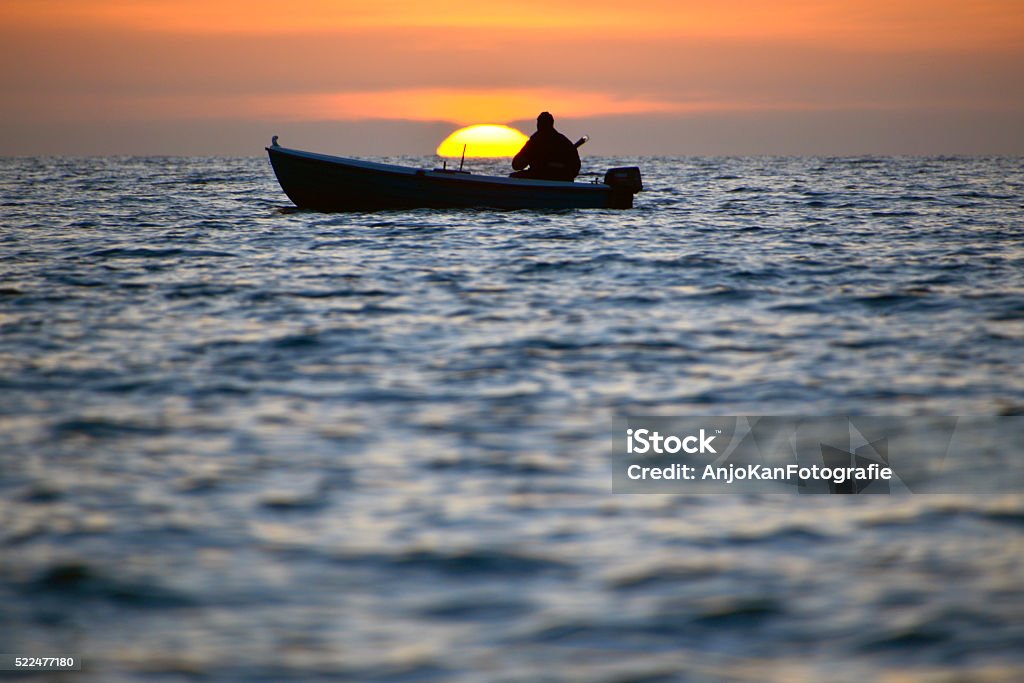fisherman with boat at sea at beautiful sunset fisherman with boat at Aegean sea, with sunset at the horizon Molivos Lesvos Greece Adult Stock Photo