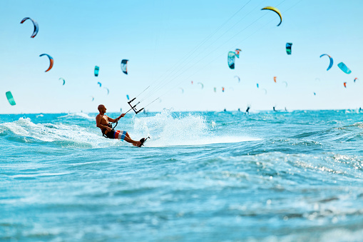 Kiteboarding, Kitesurfing. Water Sports. Professional Kite Surfer In Action On Waves In Ocean. Extreme Sport. Healthy Active Lifestyle. Hobby. Recreational Sporting Activity. Summer Fun, Adventure